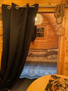 BeauvoisinLe charmant Pod du Parolais的小木屋内一间卧室,配有一张床