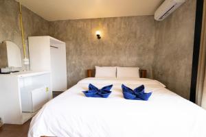 象岛Mimo Guesthouse的一间卧室配有一张白色床,上面有蓝色的弓