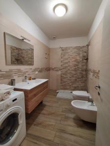 莱维科特尔梅Appartamento Nido in centro的一间带两个盥洗盆和洗衣机的浴室