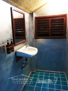 拜县拜县别墅的一间带水槽的浴室和蓝色瓷砖地板。