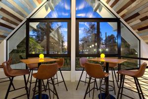 苏林海滩Outrigger Surin Beach Resort - SHA Extra Plus的带大窗户的客房内的2张桌子和椅子