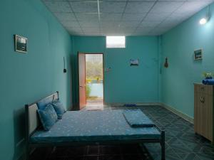胡志明市Cu Chi Boutique Farmstay的一间设有床铺的卧室,位于一间拥有蓝色墙壁的房间