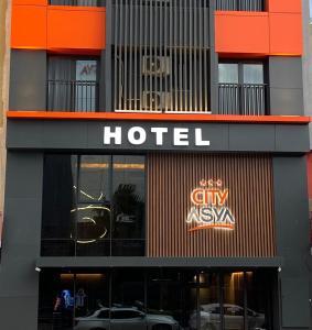 班德尔马CITY ASYA HOTEL的门前有车辆停放的酒店