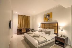多哈Corp Executive Hotel Doha Suites的酒店客房设有一张大床和一张书桌。