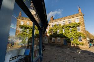 WirksworthFryers Cottage - Beautiful 2 bedroom Town & Country Cottage on edge of Peak District的商店窗户上建筑物的反射