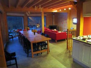 Ban-sur-Meurthe-ClefcyGrand Valtin : chalet écolo 4 étoiles 14 personnes的客厅配有桌子和红色沙发