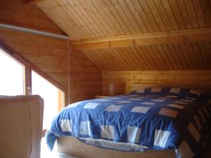 Ban-sur-Meurthe-ClefcyGrand Valtin : chalet écolo 4 étoiles 14 personnes的小屋内的一张床位,设有木制天花板