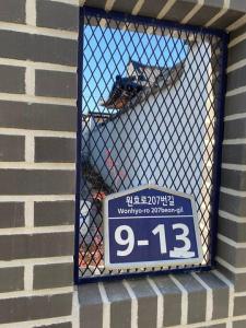 庆州Gyeongju Sugi's Guesthouse的砖砌建筑窗户上的标志