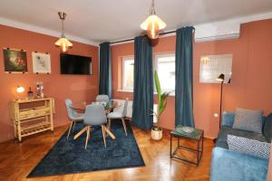 卢布尔雅那Studio City的客厅设有橙色墙壁和桌椅