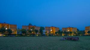 KhilchīpurAnantvan Ranthambore By ShriGo Hotels的一群晚上在田野的建筑物