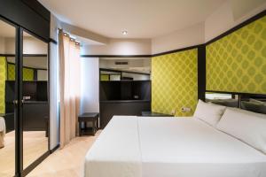 加瓦蓬特14号汽车旅馆的卧室配有白色的床和黄色的墙壁