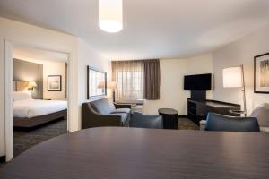 席勒公园Sonesta Simply Suites Chicago O'Hare Airport的酒店客房设有一张桌子和一张床