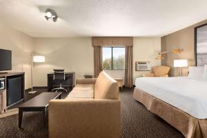 林垦速8林肯北酒店的酒店客房设有一张大床和一张沙发。