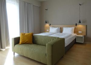 萨图马雷Marida Hotel的一间卧室配有一张大床和一张沙发