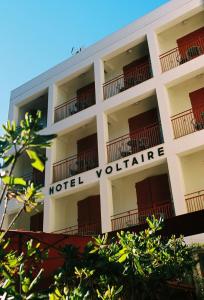 阿尔勒Hôtel Voltaire的上面有酒店志愿者标志的白色建筑