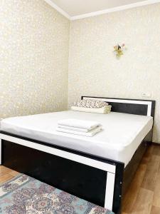 阿拉木图Apartments Ahmetova 4 21的一张带黑色框架和白色床垫的床