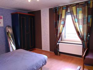 勒瓦德约尔gite chez Maise的一间卧室配有床和带窗帘的窗户