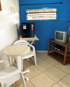阿拉夏奇巴海滩Pousada Canto do Mar Ilha Grande的配有电视的客房内的桌椅