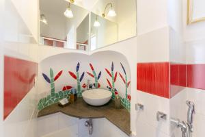 普罗奇达TORRETTA CORRICELLA- Torretta的浴室设有白色水槽和红色及白色瓷砖
