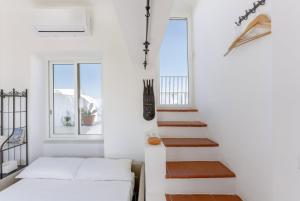 普罗奇达TORRETTA CORRICELLA- Torretta的白色客房的楼梯,配有白色沙发