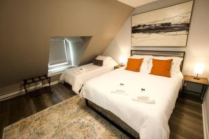 沃尔瑟姆Entire Cozy House near Moody St, Bentley, Brandeis的一间卧室配有两张带橙色枕头和地毯的床。