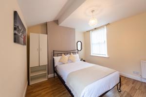 利物浦Holly Room的一间卧室配有一张带白色床单的床和一扇窗户。