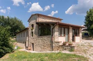 CapannucciaFAETOLE typical Tuscan country house near FLORENCE的田间中的小石头建筑