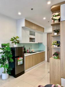 河内96Housing - Homestay Vinhomes Smart City, Tây Mỗ, Nam Từ Liêm, Hà Nội的厨房配有白色橱柜和黑色冰箱。