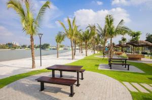 河内96Housing - Homestay Vinhomes Smart City, Tây Mỗ, Nam Từ Liêm, Hà Nội的一个带长椅和棕榈树的公园