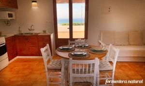 埃斯卡洛Apto Mar de Es Caló, a metros de la playa - Formentera Natural的厨房以及带桌椅的用餐室。