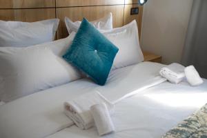 达赫拉Karam City Hotel的白色的床,带毛巾和蓝色枕头