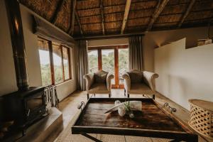 阿马卡拉保护区Bukela Game Lodge - Amakhala Game Reserve的客厅设有壁炉和桌子