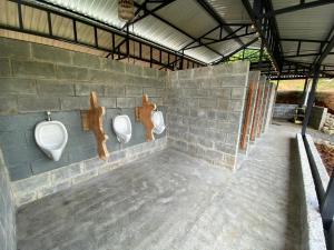 奎波斯城Esquipulas Rainforest的砖墙上带三个小便器的浴室