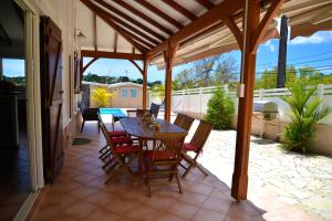 勒迪亚芒Villa Sohalia climatisée, piscine et jardin à 5mn de la plage的庭院里设有桌椅。