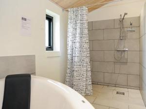 安斯艾厄8 person holiday home in Ansager的浴室配有白色浴缸和淋浴。