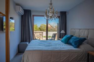 德尔迪阿布罗角Muelles del Diablo Tranquilo的一间卧室配有一张带蓝色枕头的床和一扇窗户。