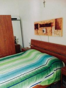 维博瓦伦蒂亚码头La Casetta Bianca Vicino Mare的卧室内的一张床铺,墙上有十字架