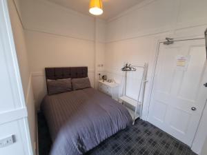 斯特兰拉尔Windsor house的一间小卧室,配有床和白色的门