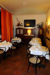 波吉邦西Albergo Italia di Nardi Renzo & C Snc的一间带桌椅和电视的用餐室