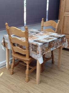 托特兰Little Bassett Bed & Breakfast的一张带两把椅子的木桌和一张带桌布的桌子