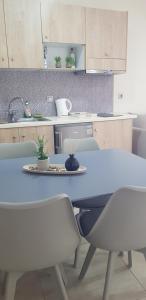 巴利恩Joanna Apartments的厨房配有蓝色的桌椅和桌椅