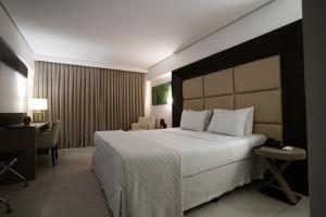 若昂佩索阿卡博布兰科阿特兰蒂克酒店的酒店客房设有一张大床和一张书桌。
