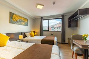 库斯科Tikala Cusco Boutique Hotel的酒店客房设有两张床和窗户。