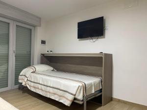 诺切拉苏普里奥勒Teddy'sRoom的卧室配有一张床和壁挂式平面电视。