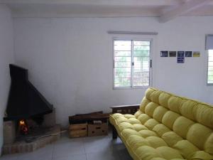 拉埃斯梅拉达Casa en La Esmeralda Uruguay的客厅设有黄色沙发和壁炉
