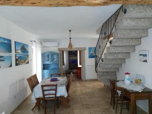 圣特奥多罗Stazzo vista mare的一间带桌子和楼梯的用餐室