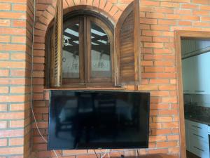 本图贡萨尔维斯Sítio Vale dos Vinhedos的砖墙中的电视,设有2个窗户