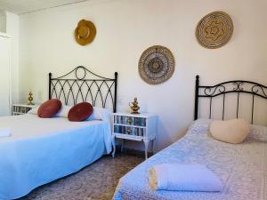 BolullaCa Àngela的一间卧室设有两张床、一张桌子和一个架子。
