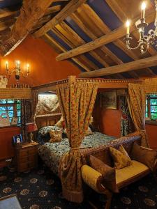 阿尔德利埃奇维兹塔旗豪华套房酒店的一间卧室配有一张天蓬床、一张沙发和一把椅子