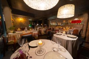 古多里Ati Ambavi Botique Hotel Gudauri的餐厅配有白色的桌椅和蜡烛